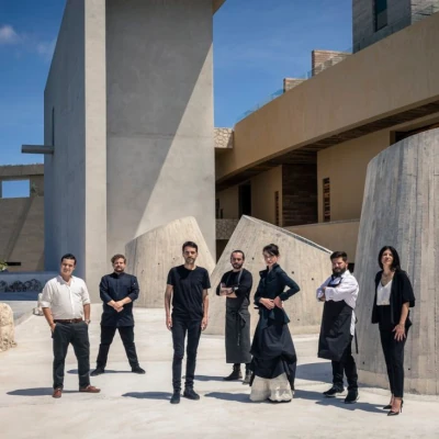 Equipo gastronómico posando en Casa de la Playa, con arquitectura contemporánea de fondo, reflejando innovación y colaboración culinaria.