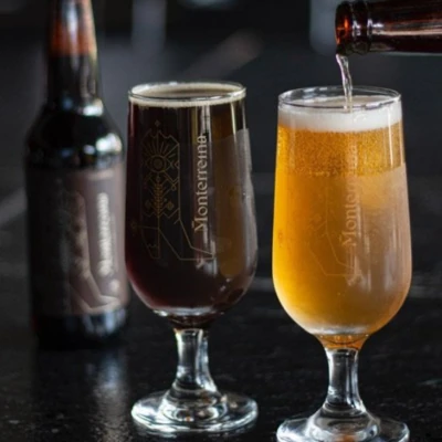Dos cervezas artesanales Monterreina servidas en copas, una oscura y una clara, destacando su colaboración en KOLI.